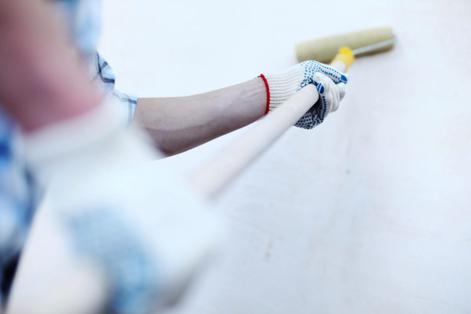 A person holding a baseball bat and wearing gloves.