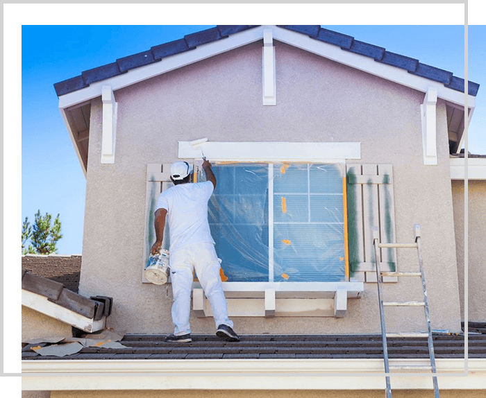 A man painting the outside of a house.