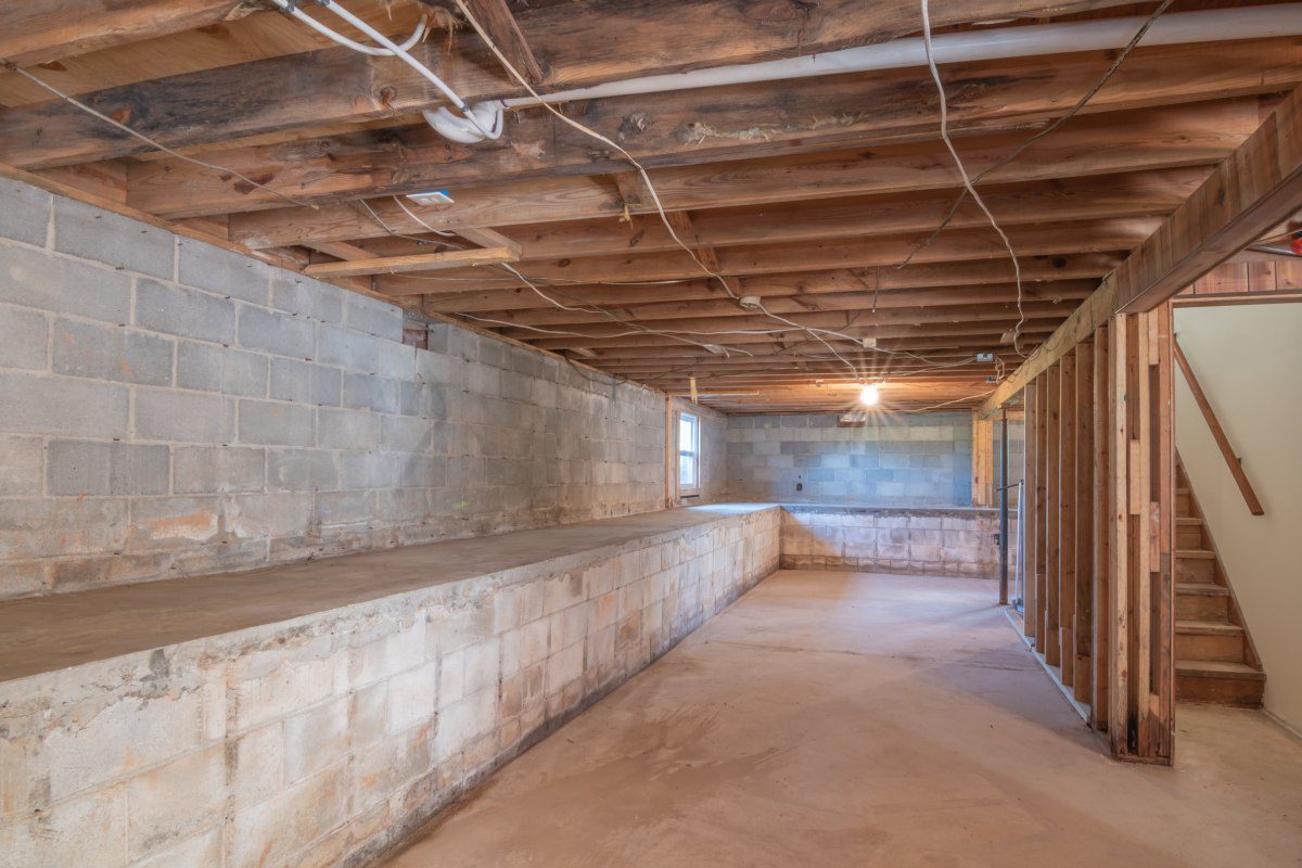 A room with exposed beams and concrete walls.
