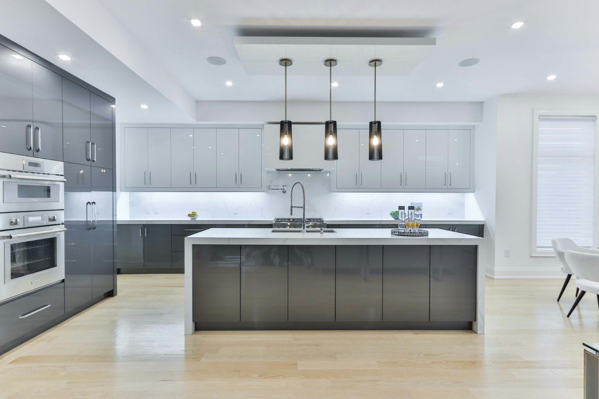 A kitchen with white walls and black cabinets.